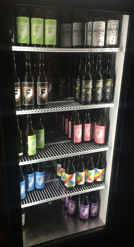 A selection of bottles for sale in the fridge at the front of the bar